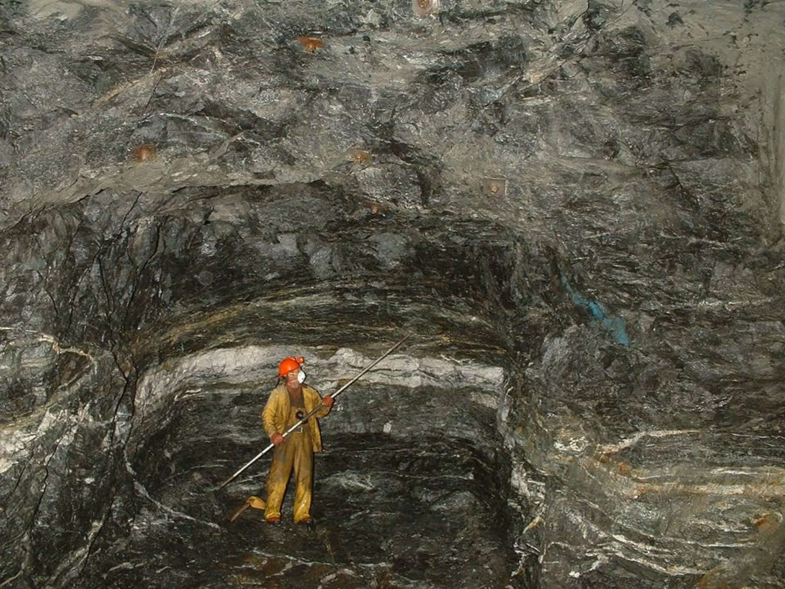 Formación rocosa con vetas de minerales coloridas, simbolizando el origen geológico de los nutrientes.