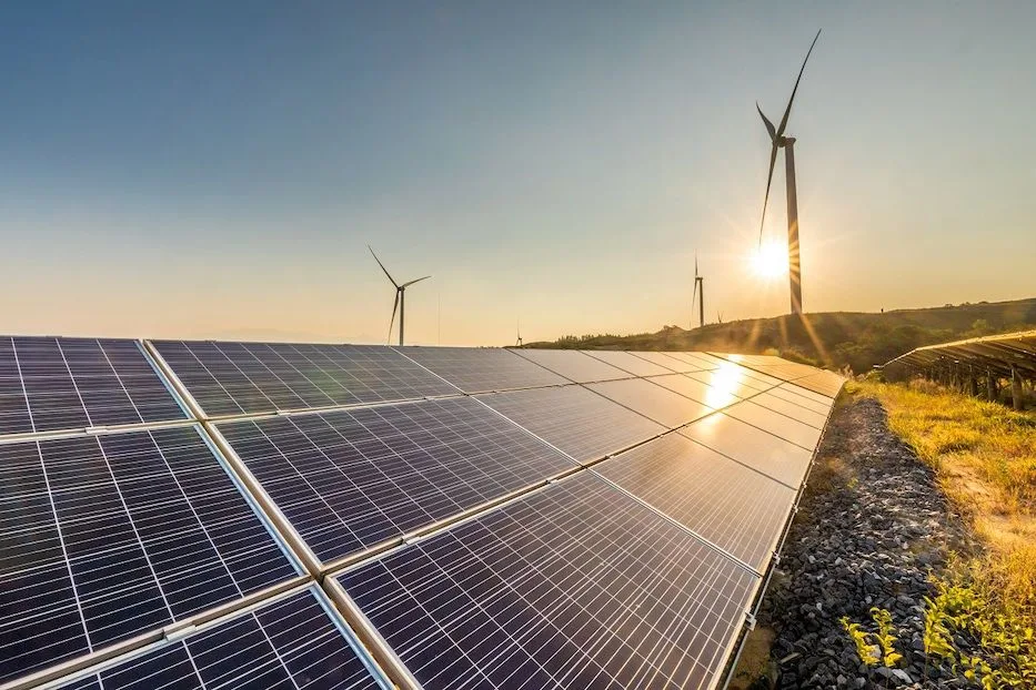 Parque de energía renovable con turbinas eólicas y paneles solares, simbolizando la transición energética que impulsa la demanda de minerales críticos.