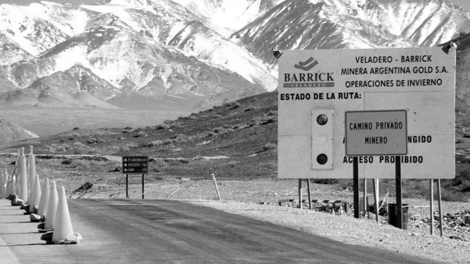 Entrada al camino de la mina Veladero en la cordillera de San Juan, con un cartel de bienvenida y montañas áridas de fondo.