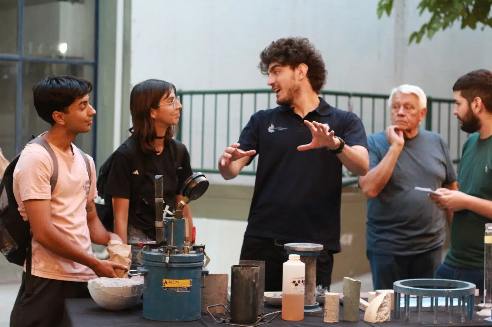 Vista de stands universitarios con estudiantes y visitantes, mostrando carreras e investigaciones de ingeniería.