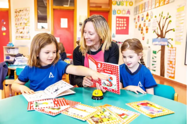 Maestra dando clases a niños de primaria en un aula.