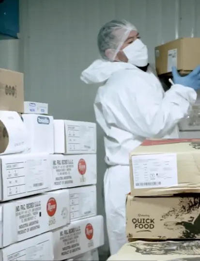 Imagen de un operario manipulando cajas con alimentos en un depósito