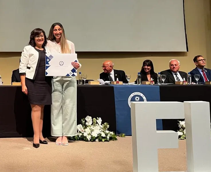 La recién egresada en Ingeniería de Minas, Ximena Ávila, recibe su diploma de manos de la decana Andrea Díaz.