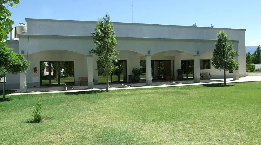 Vista exterior del Apart Hotel Olivos del Sol en Pocito, con sus jardines y olivos, un destino para el turismo minero.