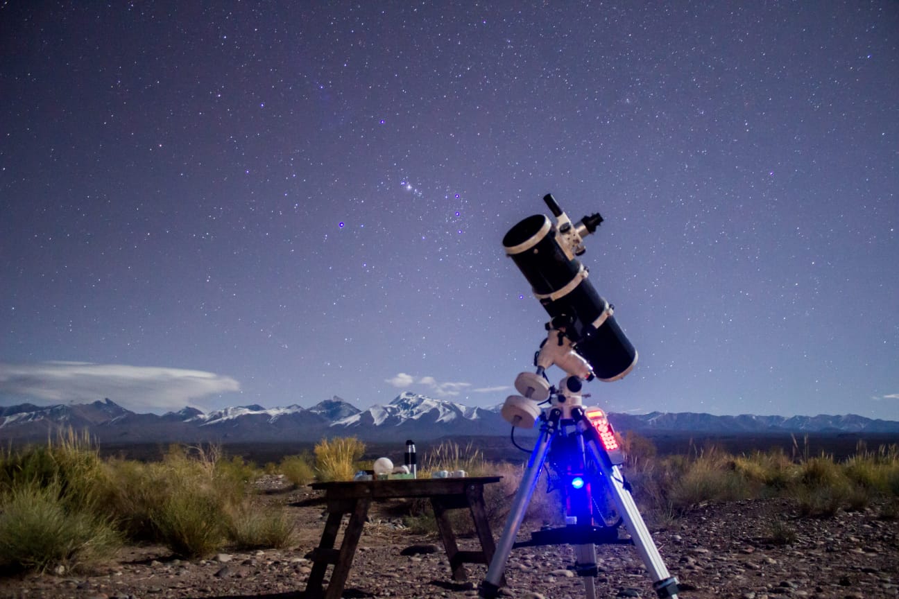 Imagen de un telescopio con al cordillera de los Andes de fondo