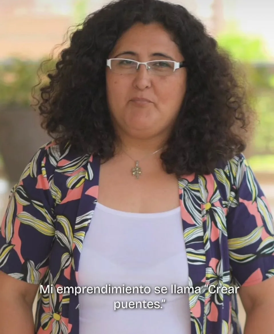 Gisela Ibáñez, mujer morena con cabello oscuro gesticulando mientras presenta su proyecto "Crear Puentes".