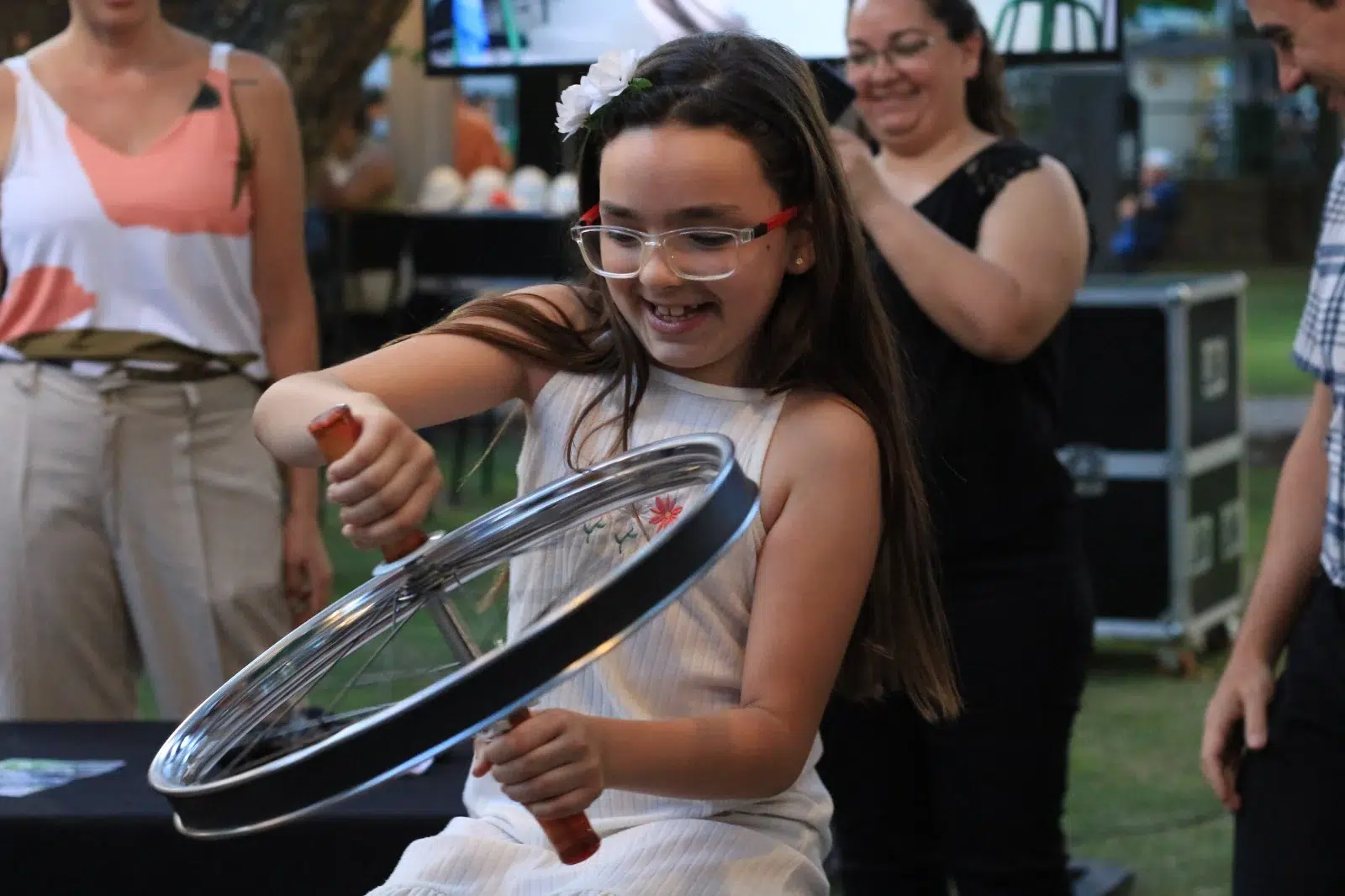 Niña con gafas de protección jugando o experimentando en un stand de ciencia interactiva.