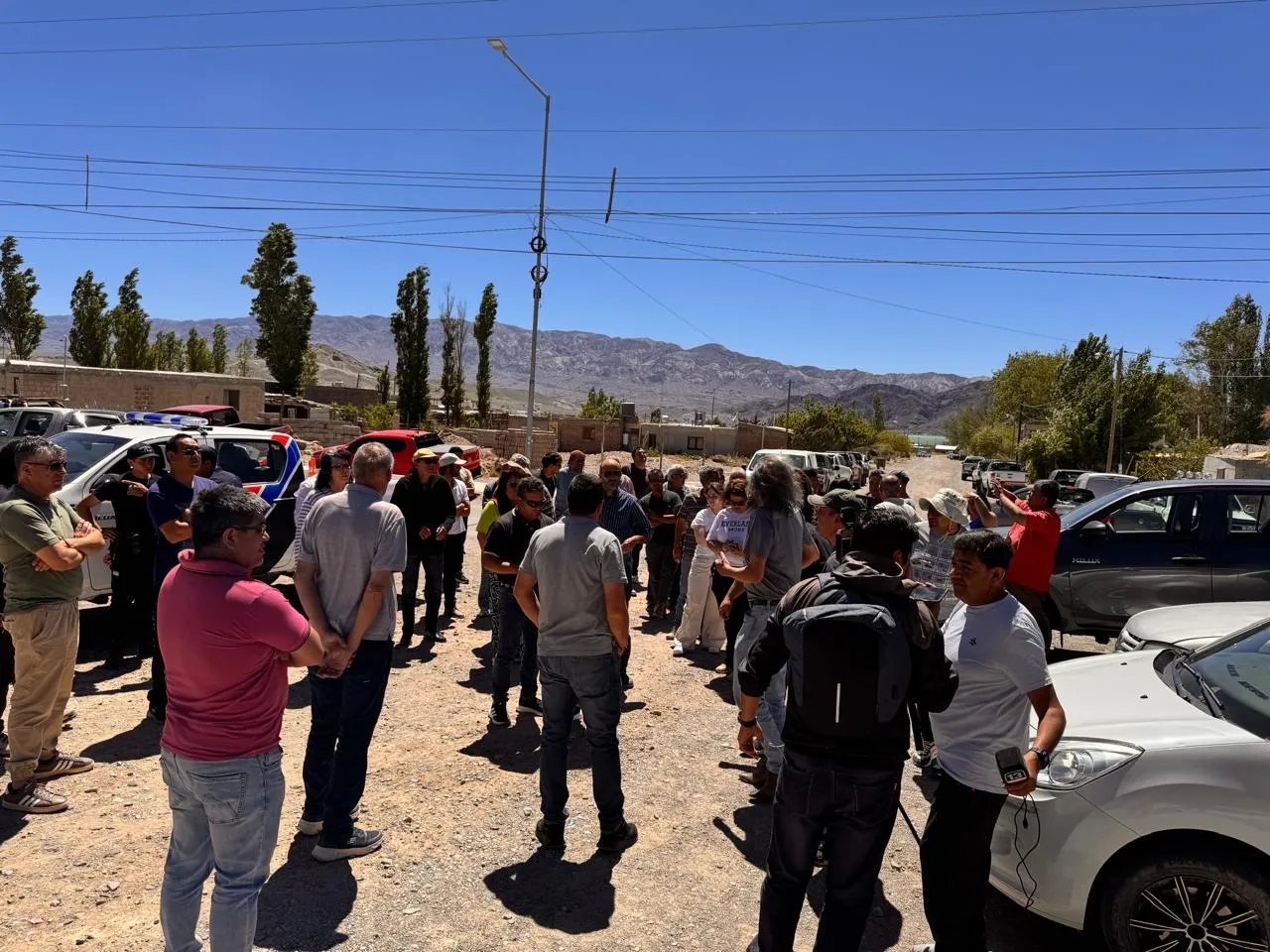 Camionetas de servicios mineros, con personas congregadas, en una manifestación en una localidad minera.
