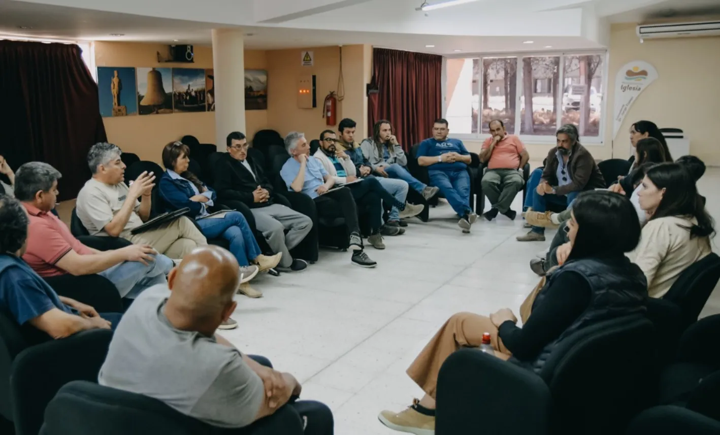 Grupo de personas sentadas en círculo en una reunicón entre empresas y cámaras mineras.