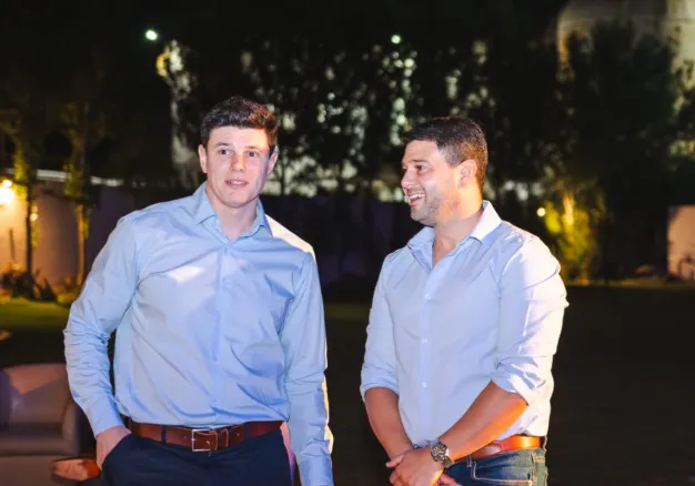 Bruno Olivera, senador, de pie junto a otra persona en un evento, representando la participación de figuras políticas.