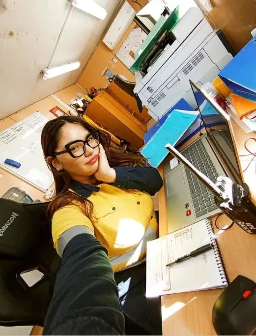 Yamila Montiel, operadora de residuos, concentrada en el escritorio con papeles y computadora en la oficina de gestión de residuos.