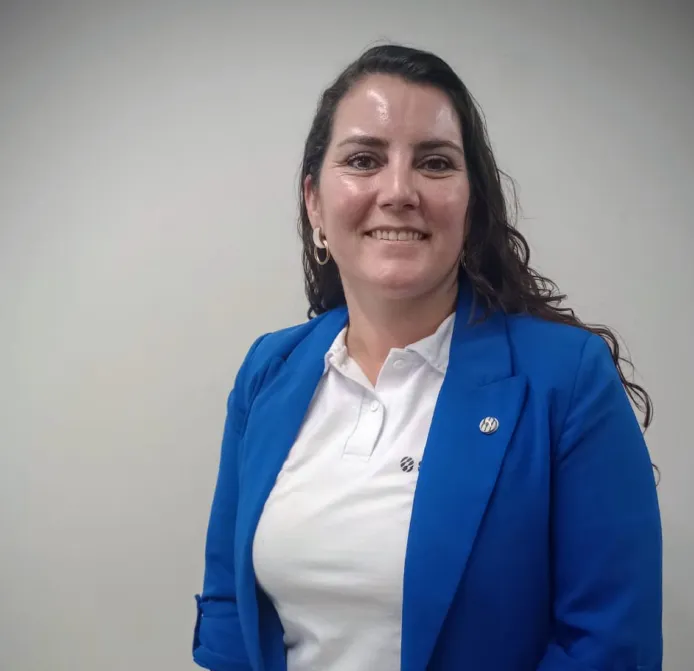 Sandvik automatización y minería: Retrato de Paula Arratia, mujer sonriente, con un fondo industrial, representando a una ingeniera de Sandvik.