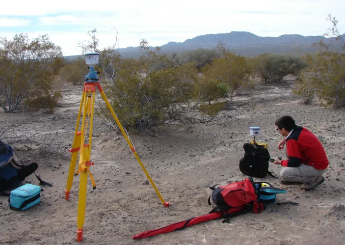 Monitoreo ambiental minería moderna: Biólogo tomando mediciones de flora y ecosistema en terreno de alta montaña