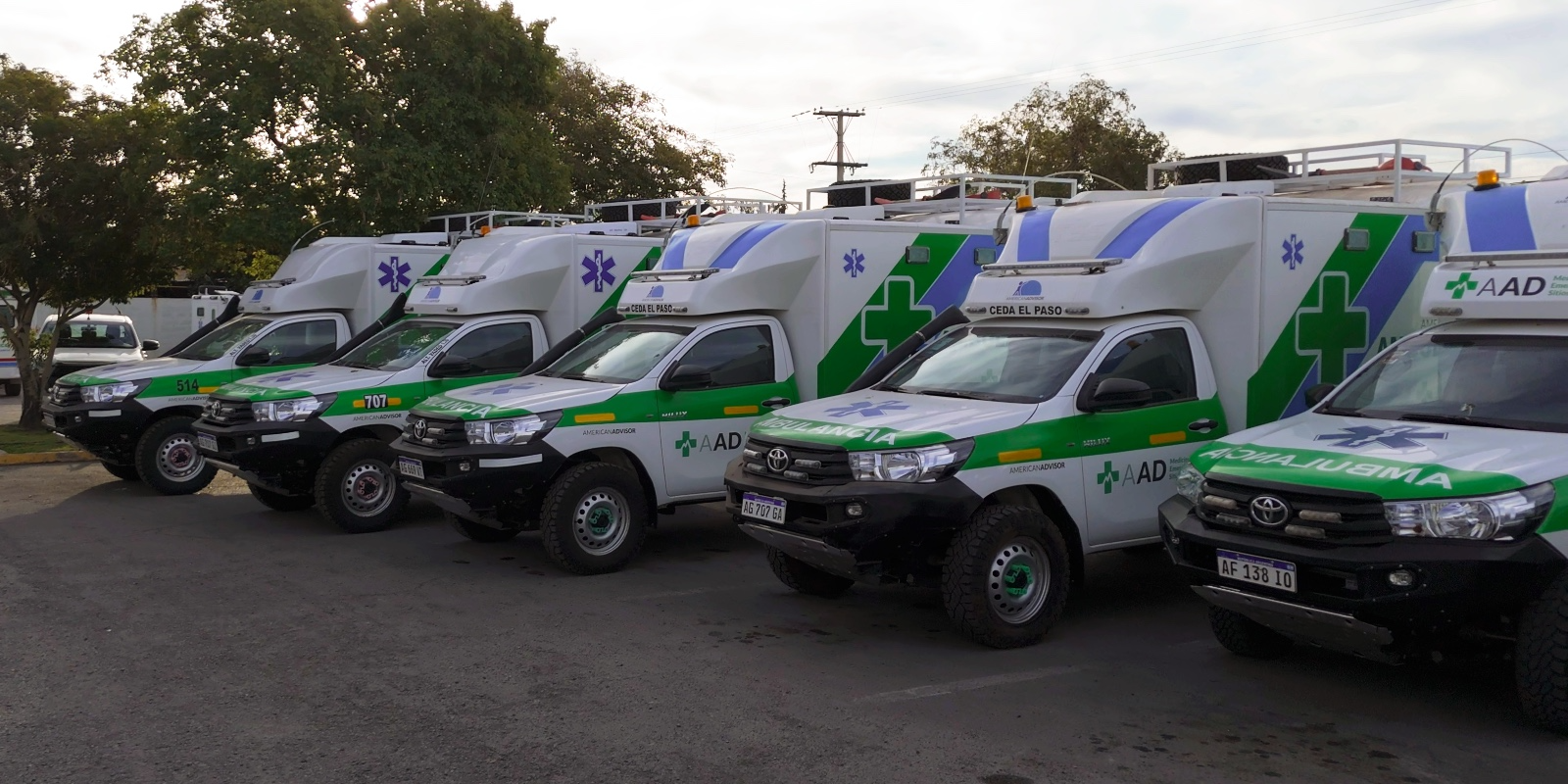  Varias ambulancias 4x4 blancas estacionadas en fila, listas para operaciones en terrenos difíciles.