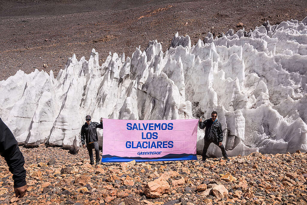 Miembros de Greenpeace con un cartel manifestándose en una zona de glaciares