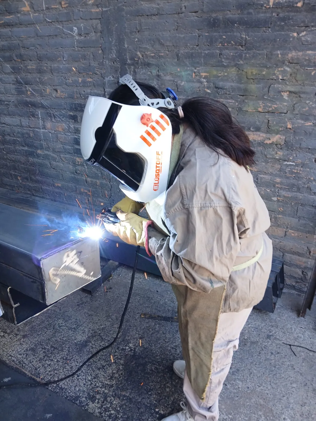 Mujeres aprendices de Metalúrgica Liniers armando muebles de oficina, capacitación metalurgia San Juan.