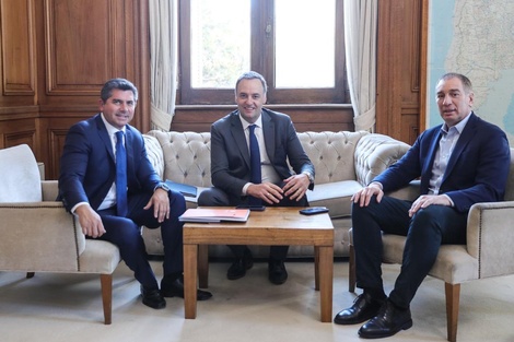 Marcelo Orrego, gobernador de San Juan, de pie junto a Manuel Adorni y Diego Santilli, en una reunión política sobre temas de provincia y nación.
