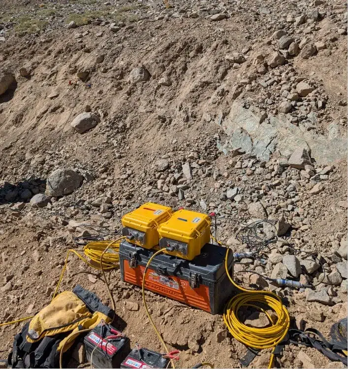 Equipos de medición geofísica instalados en terreno rocoso.