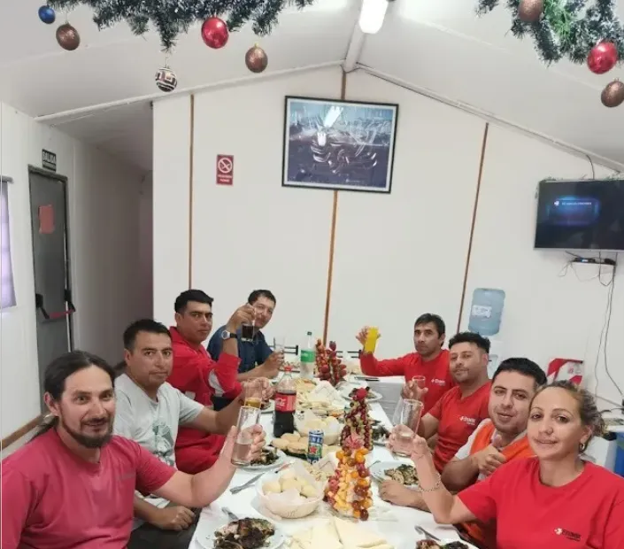 Trabajadores mineros celebrando Navidad en un comedor de campamento.