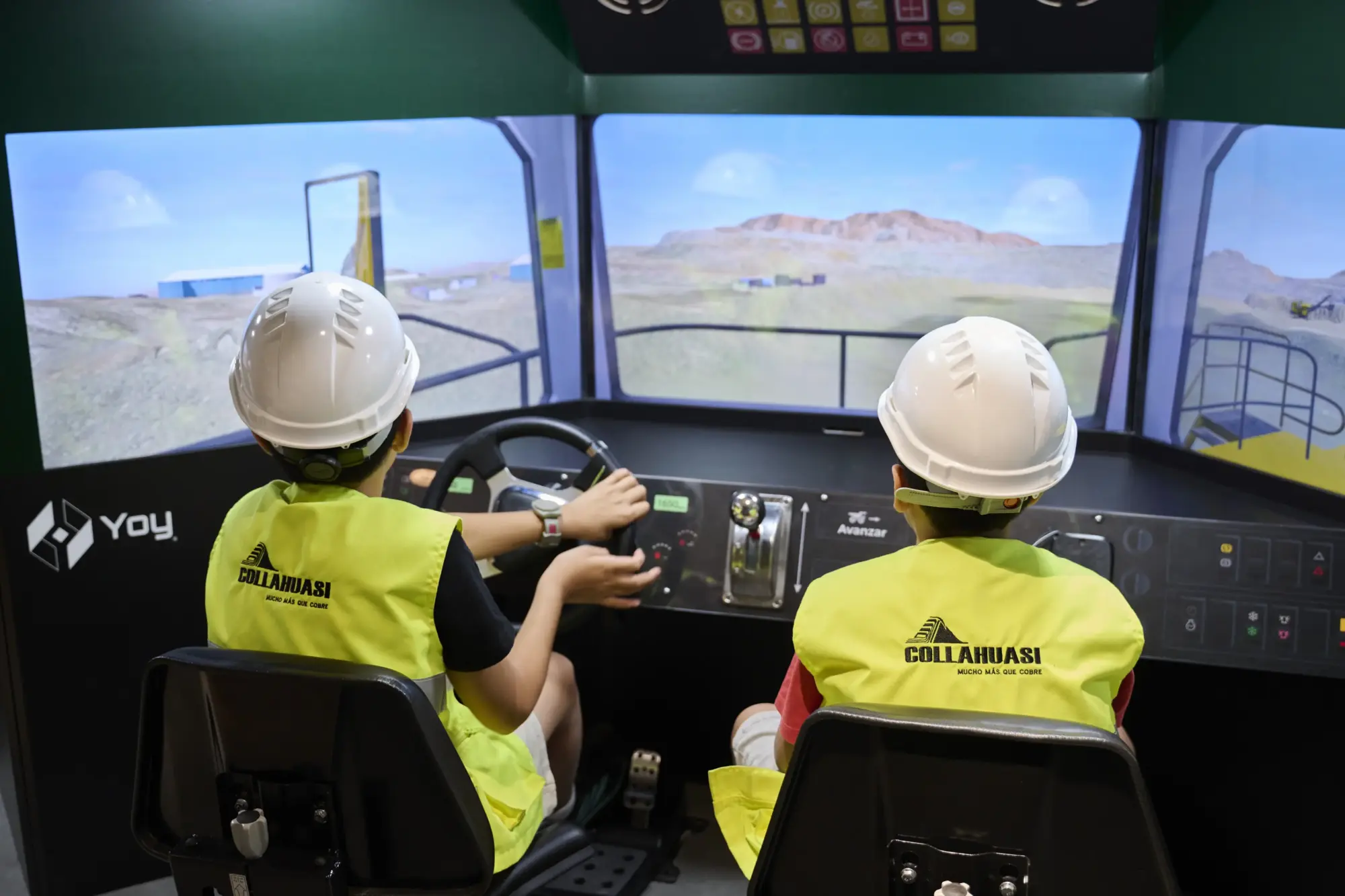 Niños utilizando simulador de realidad virtual de camión minero.