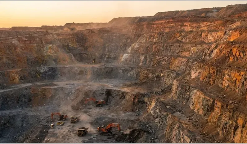 Imagen de ACERO Y ROCA Camiones autónomos y drones operan junto a antiguos castilletes en desuso, simbolizando la reactivación tecnológica de viejas minas. Imagen ilustrativa de Acero y Roca.