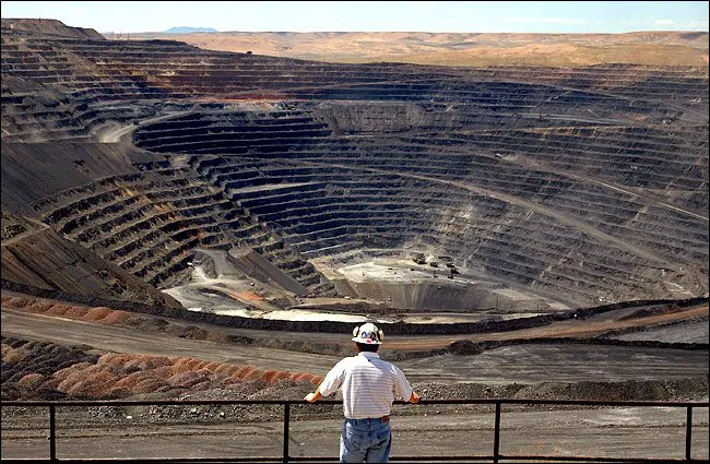 Fotografía aérea a gran escala de una mina de oro a cielo abierto en Nevada, mostrando los niveles de excavación y caminos perimetrales.