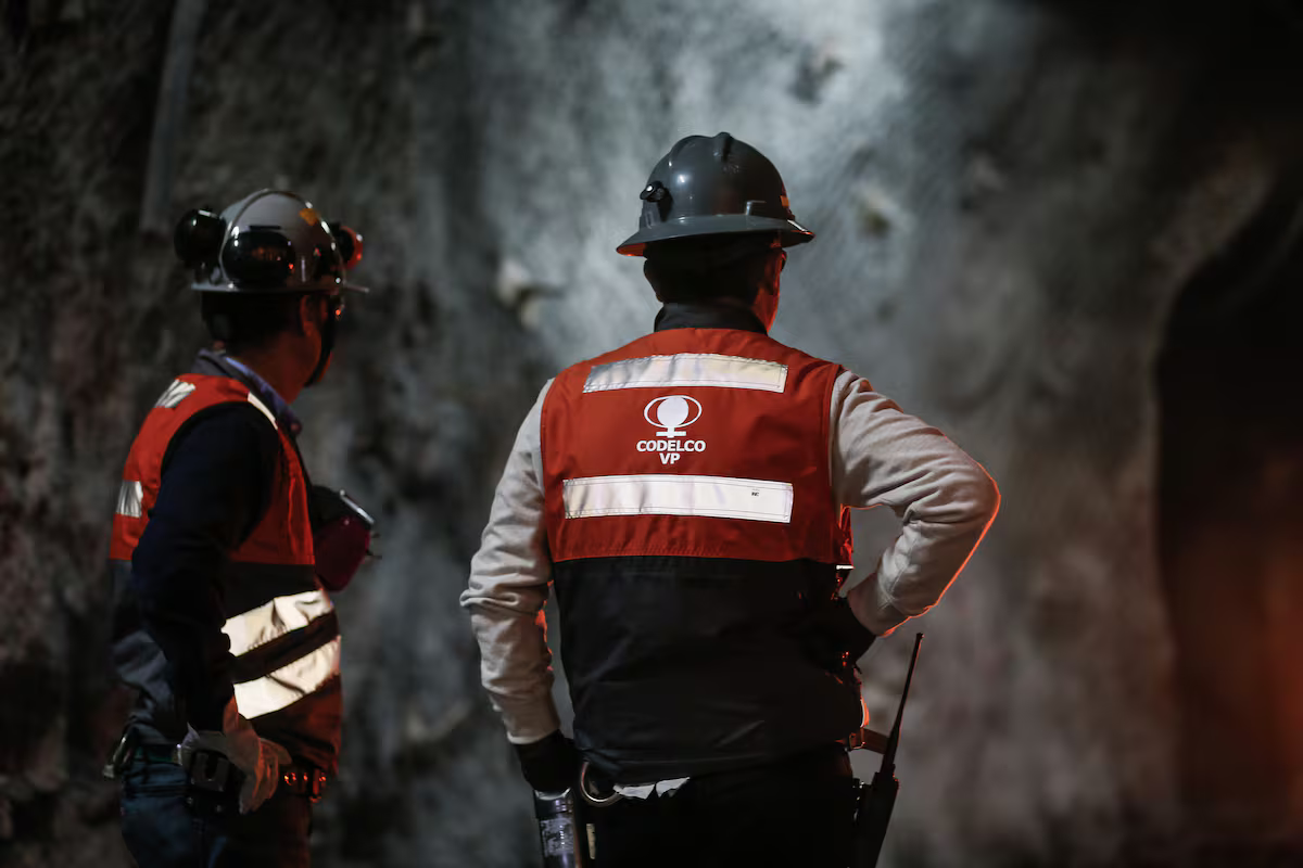 Personal técnico con chalecos reflectantes revisando planos y equipos de monitoreo en zona de operaciones.