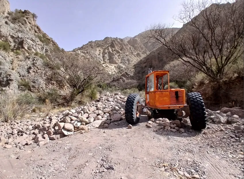Retroexcavadora pequeña operando en un lecho de río seco para minería de oro. Acero y Roca