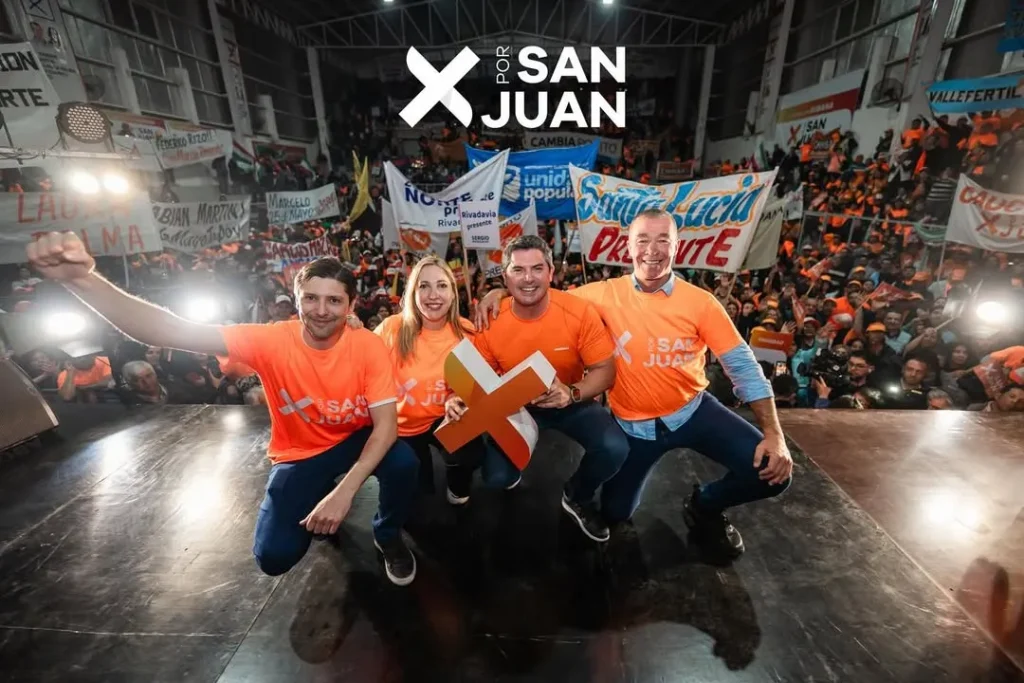 Candidatos políticos en una foto posando en un escenarios