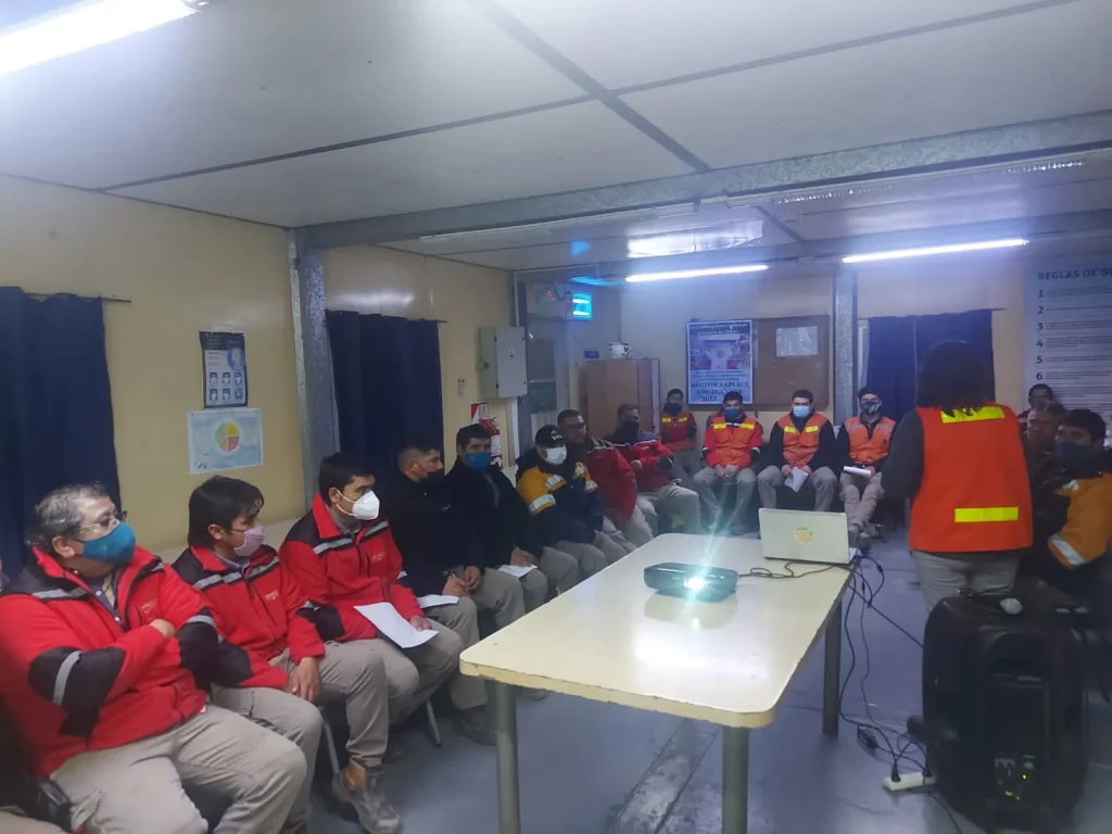 Grupo de trabajadores de una empresa minera reunidos en una charla informativa sobre el Covid 19, durante la pandemia.