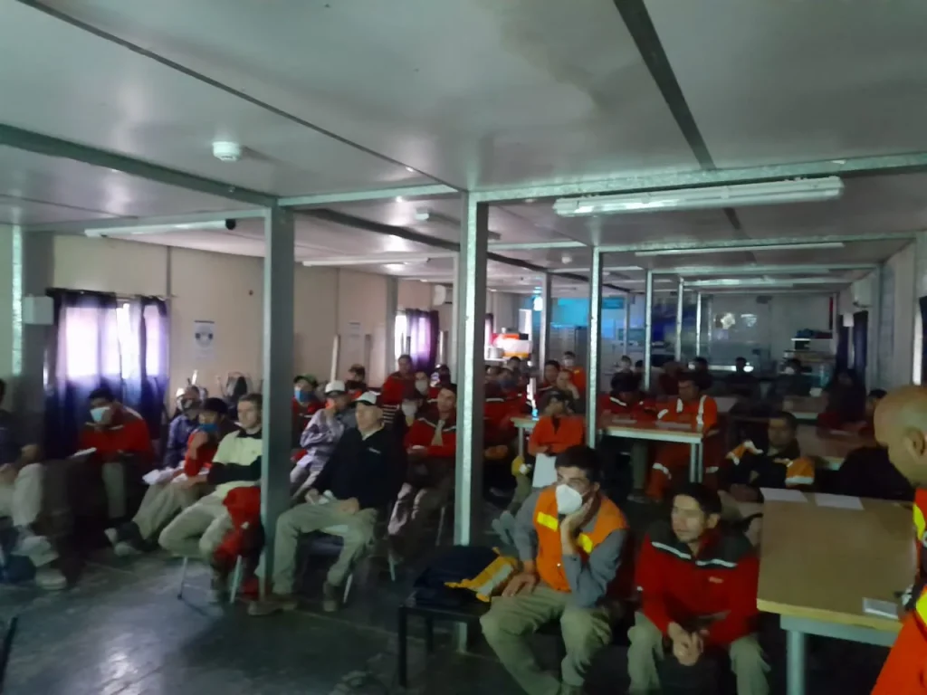 Grupo de trabajadores de una empresa minera reunidos en una charla informativa sobre el Covid 19, durante la pandemia.