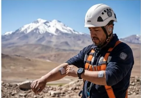 Contenido Original de ACERO Y ROCA - Prohibida su reproducción Trabajador minero con reloj inteligente y sensores de salud en alta montaña.