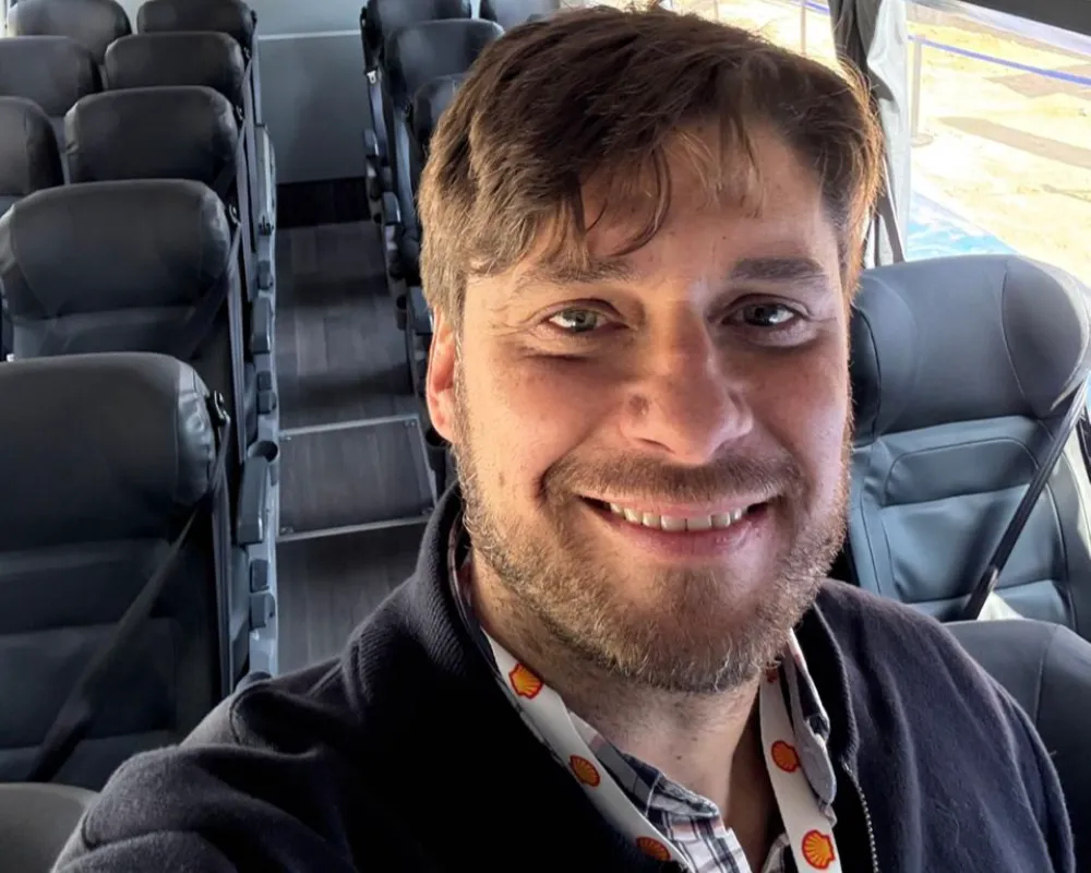 Juan Cruz Igualada sonriendo dentro de una unidad de transporte de pasajeros de la empresa PAP SRL