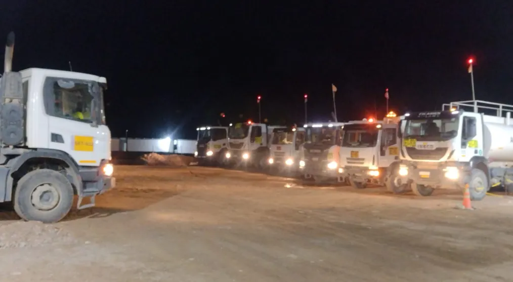 Camiones en alta montaña de noche, formados uno al lado de otro.