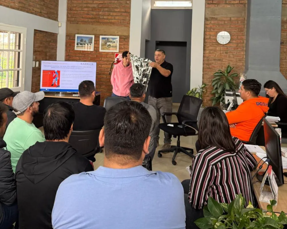 Salon lleno de personas observando a un profesor que imparte una clase de capacitacion laboral