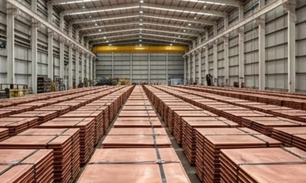 Cátodos de cobre apilados industrialmente dentro de un galpón logístico iluminado, con brillo metálico realista y perspectiva profunda. Contenido Original de ACERO Y ROCA - Prohibida su reproducción