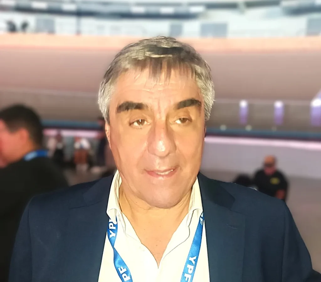 Roberto Cacciola, presidente de CAEM, conversando durante la Expo San Juan Minera, de medio cuerpo, con stand o auditorio de fondo.