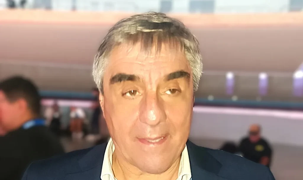 Roberto Cacciola, presidente de CAEM, conversando durante la Expo San Juan Minera, de medio cuerpo, con stand o auditorio de fondo.
