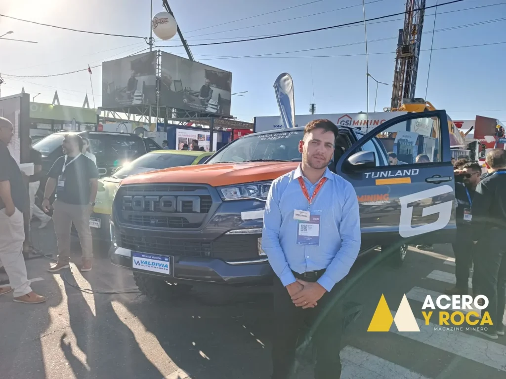 Gonzalo Barber de pie junto a una camioneta FOTON blanca de gran porte, fondo con carteles de la expo y público.