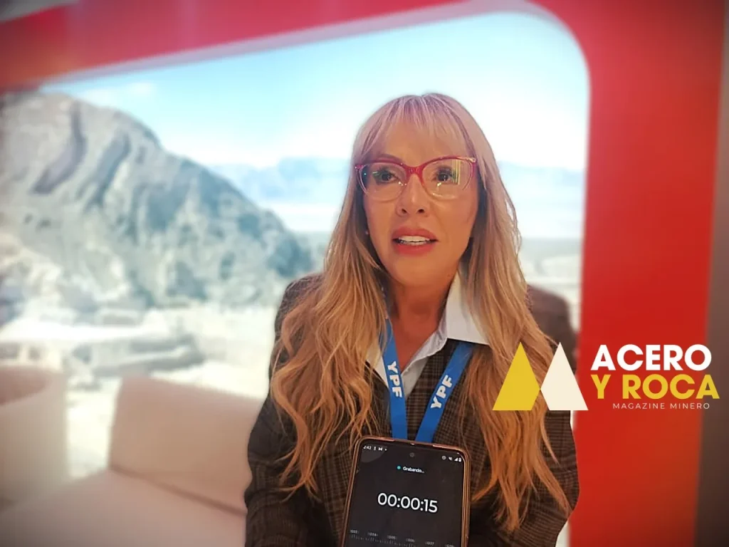 Sonia Delgado, directora de Challenger Gold, entrevistada por Acero y Roca. Mujer de traje sastre oscuro, con una carpeta en la mano, sonriendo levemente. 
