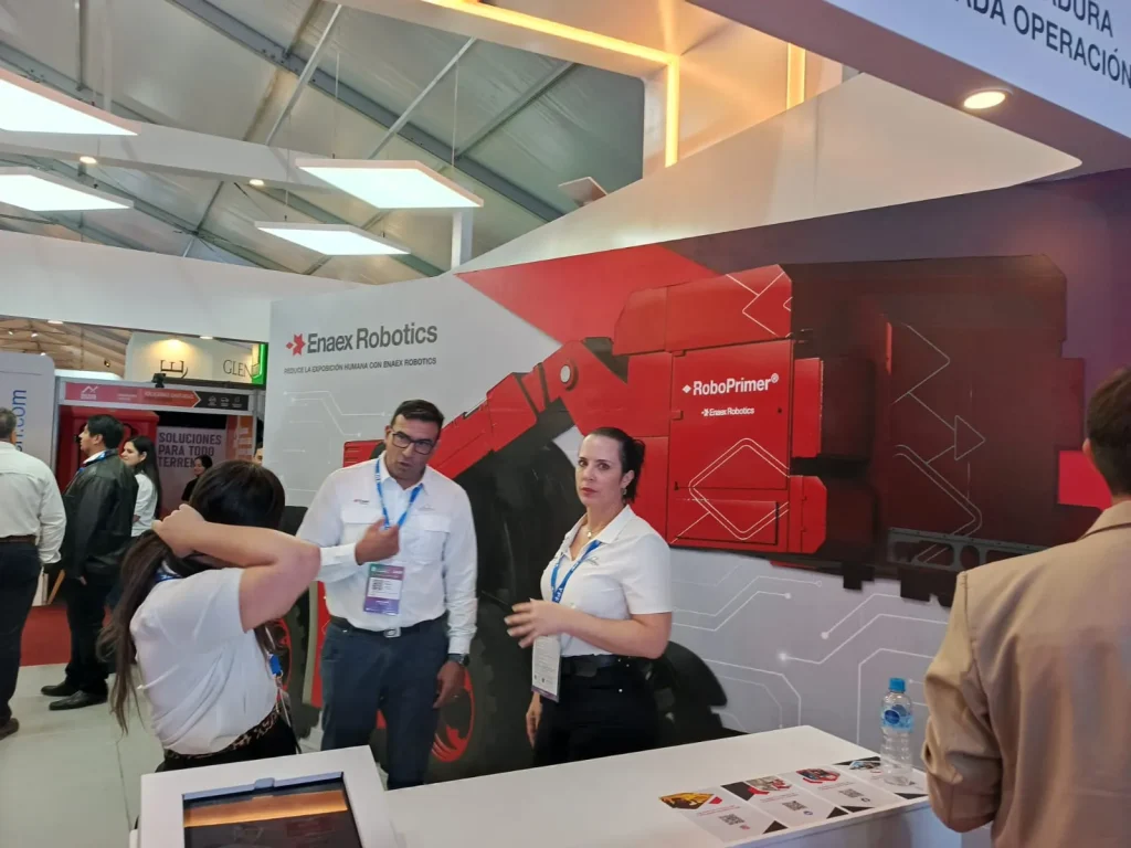Muestras de tecnología de voladura de Enaex: sistemas de iniciación electrónica, detonadores, equipos de carguío mecanizado sobre una mesa de exhibición.