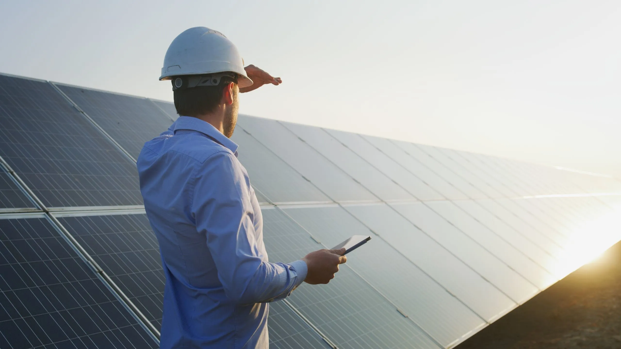 Instalador operando módulos fotovoltaicos producidos por la fábrica de paneles solares en un parque solar.