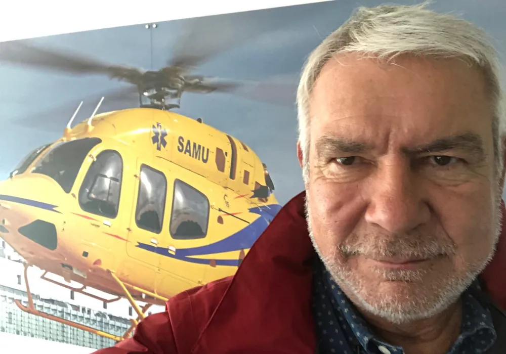 Primer plano de Walter Gallardo con un helicóptero de emergencias SAMU de fondo.