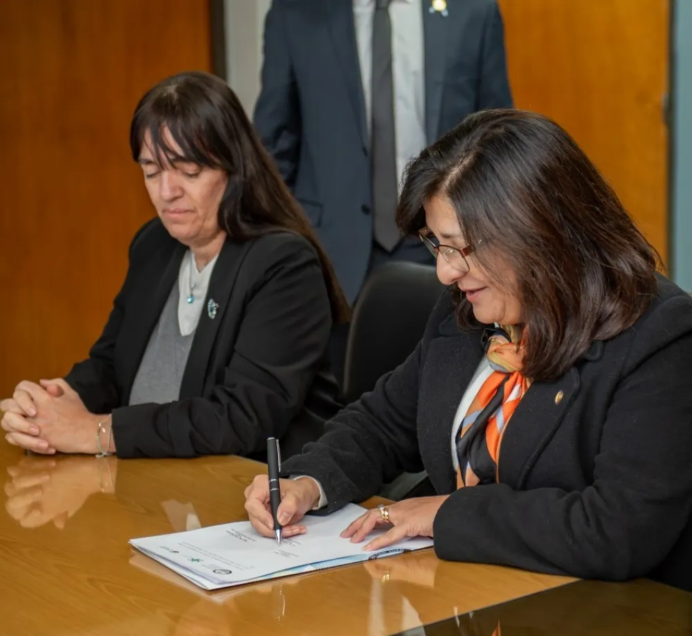 Imgagen de la decana Andrea Díaz firmando un convenio