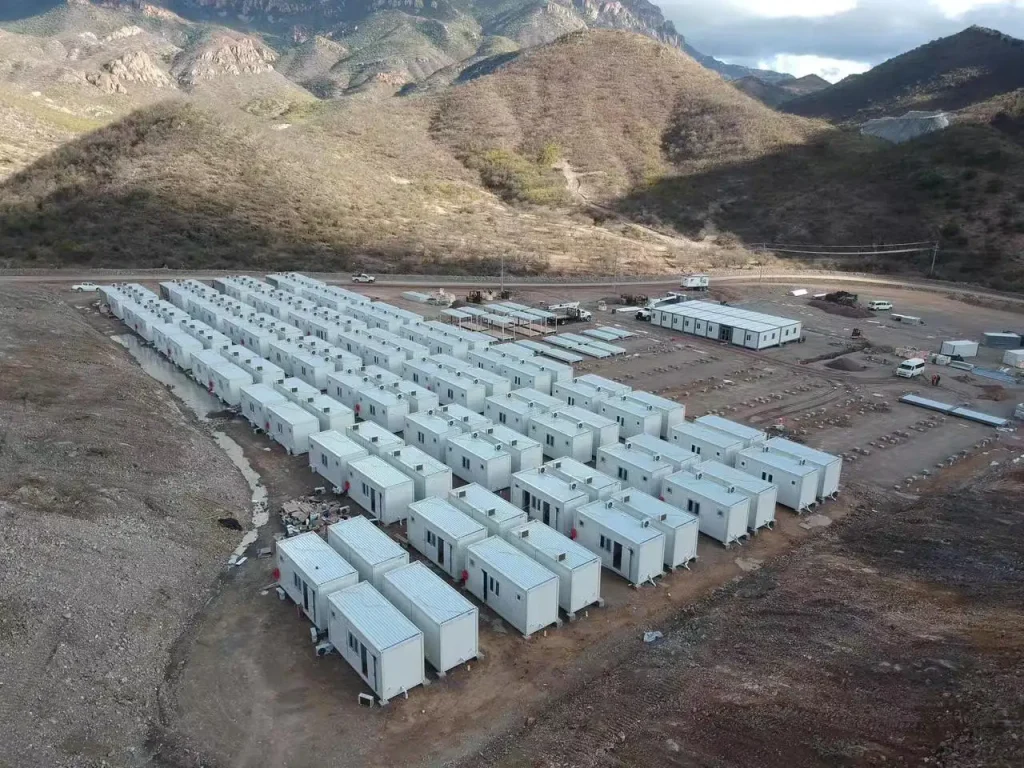 Hilera de bloques habitacionales modulares apilados en dos plantas en un entorno minero extremo.