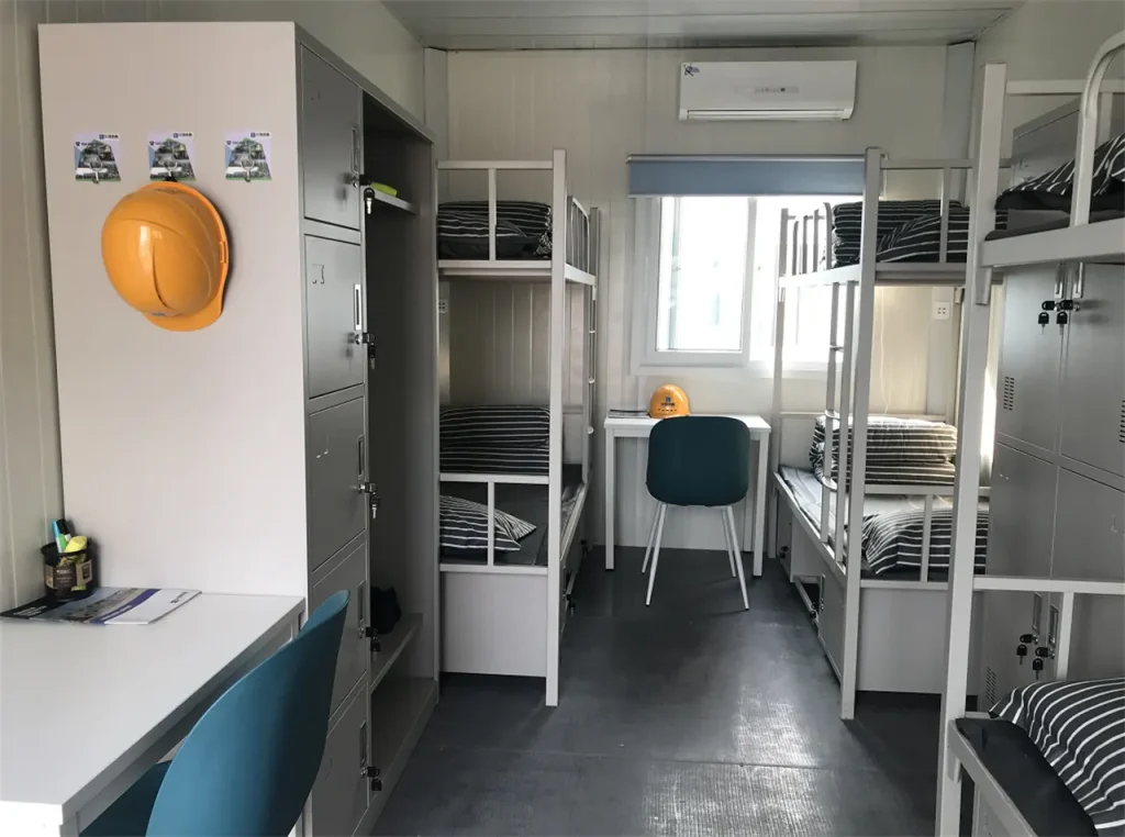 Habitación modular interna con camas amobladas y aislamiento térmico para operarios mineros.