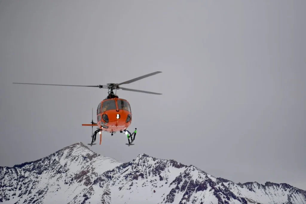 Helicóptero en pleno vuelo sobre la cordillera de San Juan, prestando servicio aéreo minero San Juan para traslados y emergencias Medevac.