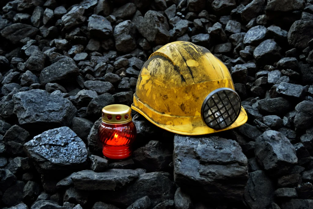 casco minero y lámpara sobre una montaña de rocas.