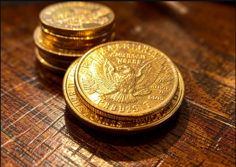 Primer plano de auténticas monedas de oro American Eagle de la U.S. Mint sobre escritorio rústico para analizar la trazabilidad del oro ilegal. Contenido Original de ACERO Y ROCA - Prohibida su reproducción