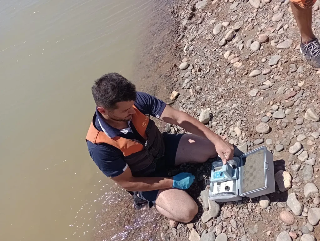 Especialistas durante la toma de muestras de agua en el dique Cuesta del Viento.
